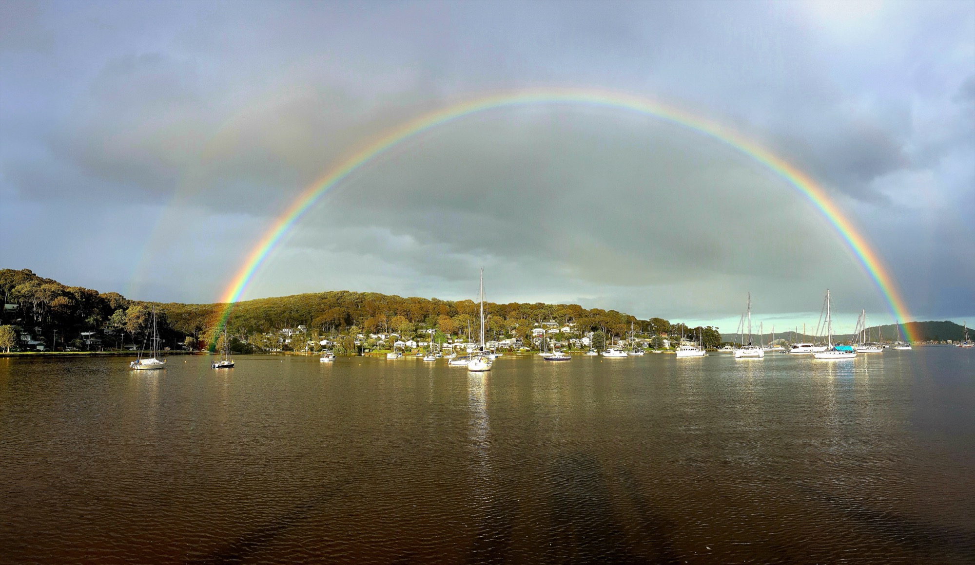 A rainbow arching over the moored boats at Hardys Bay